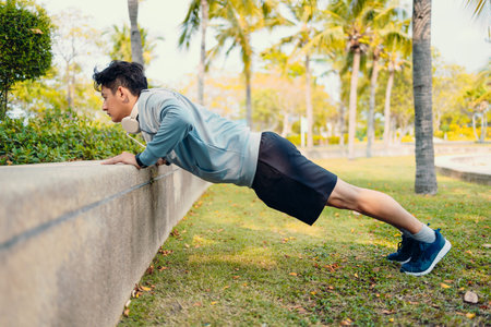 Young sportsman doing push-ups in the park. Fitness, training, workout concept.