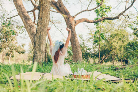 A girl raise hands up in the forest and take a deep breath fresh air.の写真素材