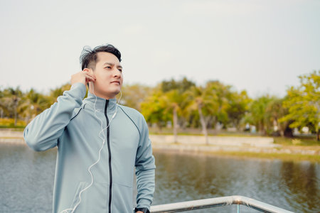 Young sport man jogging and listening music in the park.の写真素材