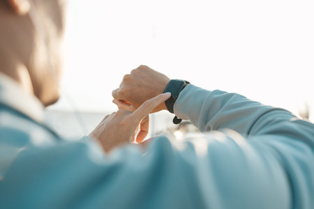sport man checking at smartwatch during training and running in the park.