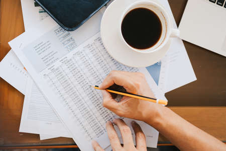 Administrator businessman making report, calculating balance. Business analyzing income charts, graphs and data on the table.の写真素材