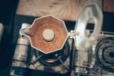 Brewing black moka coffee using moka coffee maker and boiling on stove.の写真素材