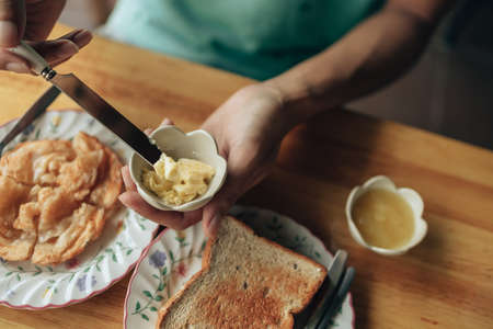 Knife pick butter in jam cup. Food and dessert concept.の写真素材
