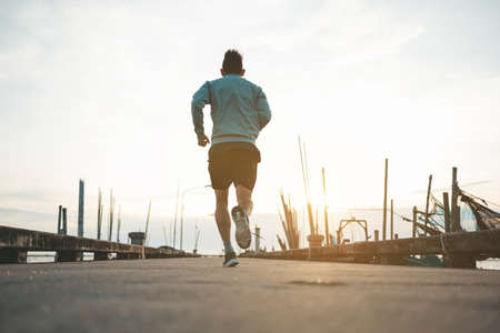 The man with runner on the road in sunset.の写真素材