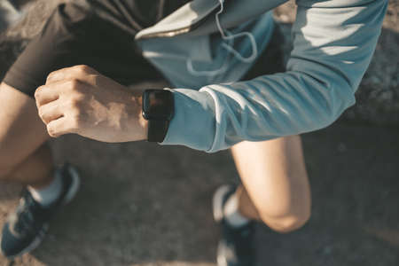 sport man checking at smartwatch during training and running in the park.の写真素材