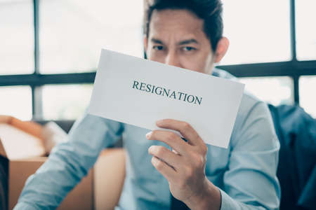 Businessman sending and showing resignation letter to employer boss. Quitting a job, businessman fired or leave a job concept.の写真素材