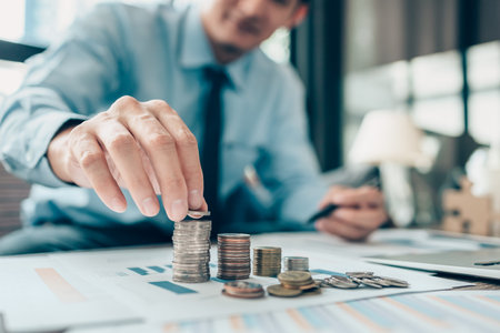 Hand putting money coins stack growing, saving money for finance accounting concept.