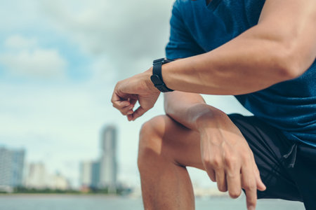 sport man checking at smartwatch during training and running in the park. Sport and technology...