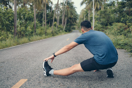 young man stretching in the park before running. Young man workout before fitness training at the...
