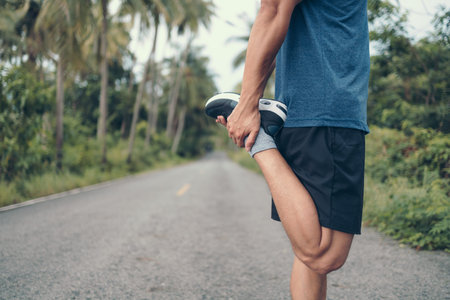 young man stretching in the park before running. Young man workout before fitness training at the...