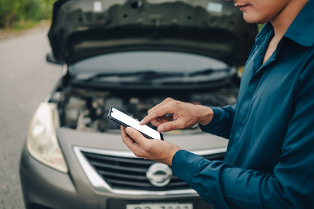 young man calling,  texting for car service on roadside assistance after broken car. Car broken, car breakdown concept.の写真素材