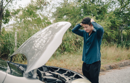 Serious man headache front of car breakdown and open bonnet on roadside. Car broken concept.