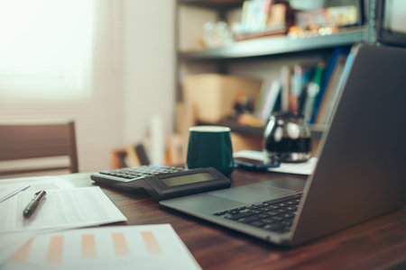 Accounting woking with data sheet on the office desk. Calculator with accounting report and...