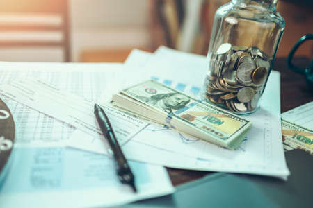 Money coin in jar and money on the table. Money savings concept.の写真素材