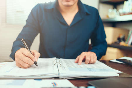 Accounting woking with data sheet on the office desk. Calculator with accounting report and financial statement on desk.の写真素材
