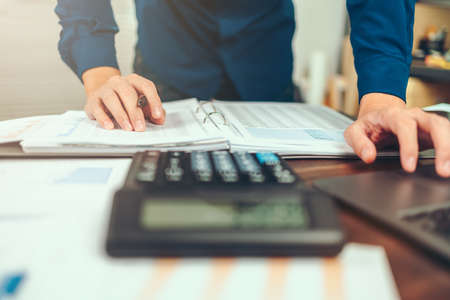 Accounting woking with data sheet on the office desk. Calculator with accounting report and financial statement on desk.の写真素材