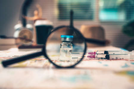 Vaccine and syringe on map. Important equipment before traveling during COVID concept.の写真素材