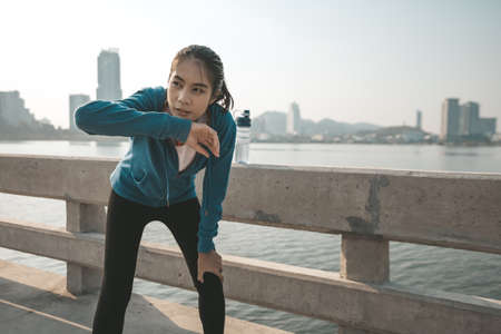 woman runner takes a break after jogging in the morining.の写真素材
