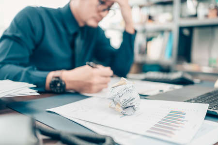 Crumpled papers on office desk. Business strain feeling was frustrated with working failed. fail, conflict, fale and problem working concept.の写真素材