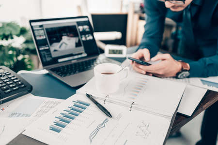 A pen on data sheet and Businessman working on office desk and analyzing new project of accounting finance. Investment, Financial advisor and accounting concept.の写真素材