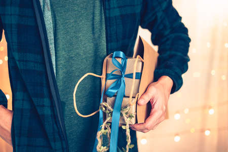 Hands holding gift box, present on the table and light of bokeh background. Valentine's Day, Christmas, Birth day, New year and Anniversary concept.の写真素材