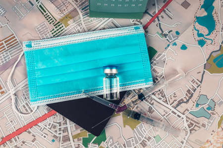 Vaccine, syringe and mask on passport. Important equipment before travelingの写真素材
