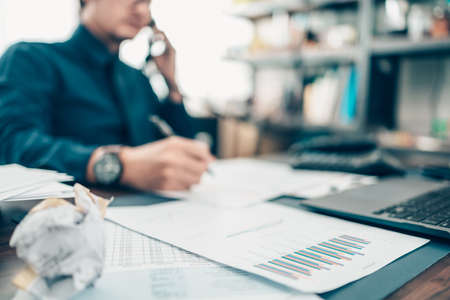 A pen on data sheet and Businessman working on office desk and analyzing new project of accounting finance. Investment, Financial advisor and accounting concept.の写真素材