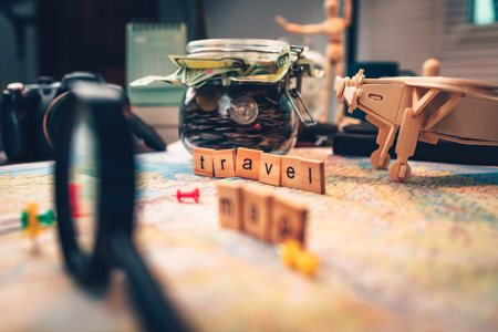 Wood square with word travel and saving money in jar on the map. pushpin showing the location of a...