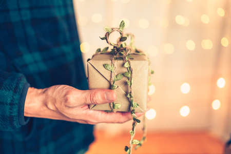Hands holding gift box, present on the table and light of bokeh background. Valentine's Day, Christmas, Birth day, New year and Anniversary concept.の写真素材