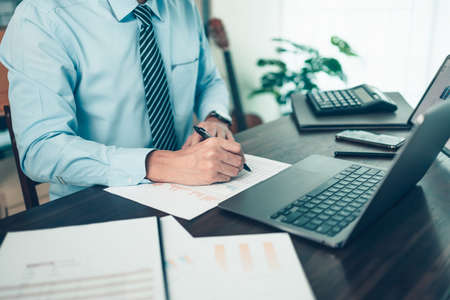 Businessman working on office desk and analyzing new project of accounting finance. Investment, Financial advisor, budget, plan and accounting concept.の写真素材