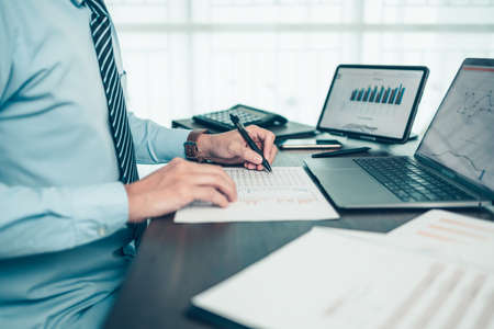 Businessman working on office desk and analyzing new project of accounting finance. Investment, Financial advisor, budget, plan and accounting concept.の写真素材