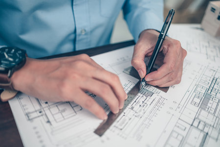 Architect engineer use pen and  angle protector drawing design working on bueprint. House planning...