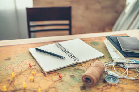 A pen on book and pin on world map. Travel , Adventure and Discovery concept.の写真素材