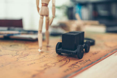 Wood doll walking on world map and other accesories for travel on the table.の写真素材