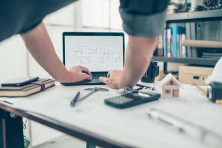 Architect engineer use laptop for check drawing design. House planning design and construction concept.の写真素材