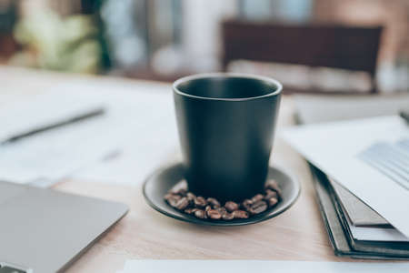 Cup of coffee on office desk and company data, document and report on the table. Accounting business concept.の写真素材