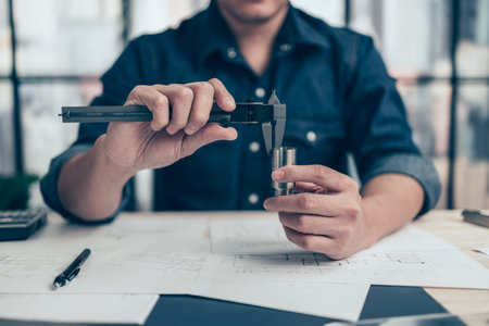 Architecture hands hold vernier caliper working and checking joint pipe scale with bathroom planning. Architecture and engineer concept.の写真素材