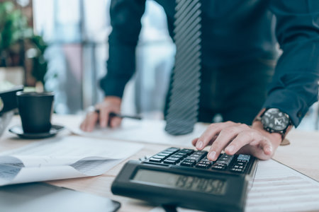 Accountant working on calculator to calculate company data, document and report on desk office....