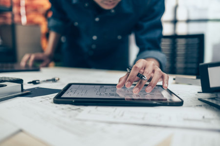 Architect engineer use tablet to read drawing design. House planning design and construction...