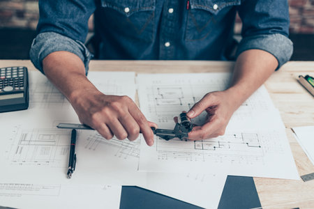 Architecture hands hold vernier caliper working and checking joint pipe scale with bathroom planning. Architecture and engineer concept.の写真素材