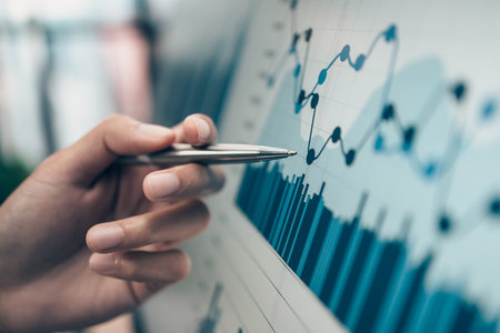 Investors working on desk office and use pen to  pointing to check graph, chart on monitor screen. Accounting and  Financial concept.の写真素材