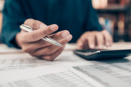 Investors working on desk office and using a calculator to calculate balance, projit, currency and...