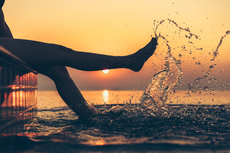 silhouette of woman in the pool water on summer vacation with sunset view.の写真素材
