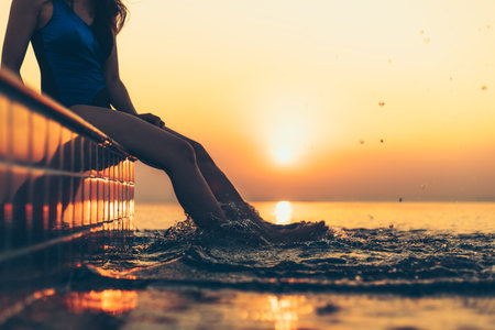 silhouette of woman in the pool water on summer vacation with sunset view.の写真素材