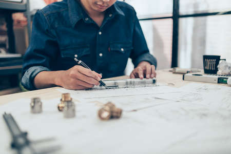 Architect engineer use pen  and mini T-slide drawing design working on blueprint. House planning design and construction concept.の写真素材