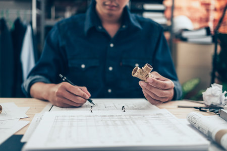Architect engineer use pen  drawing design working on blueprint and holding joint pipe. House...