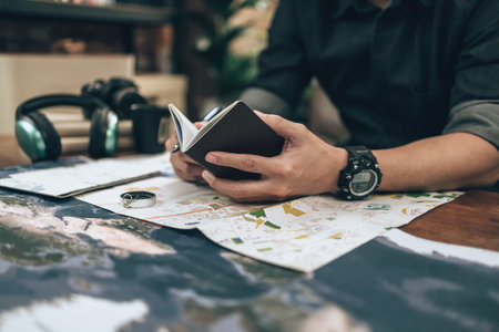 Tourist planning vacation hold passport and other travel accessories around on the table. Vocation, travel, holidays and backpack concept.の写真素材