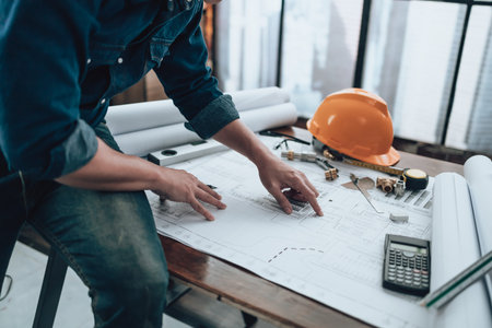 Engineering working with drawings inspection on the office desk and Calculator, triangle ruler,...