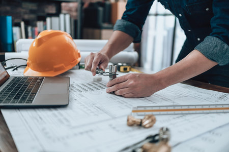 Engineering working with drawings inspection on the office desk and Calculator, triangle ruler,...
