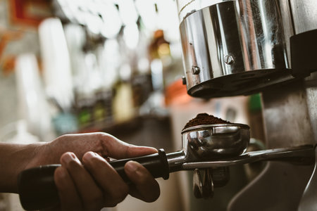 barista use bottomless filter with grinder machine at coffee shop. coffee maker concept.の写真素材